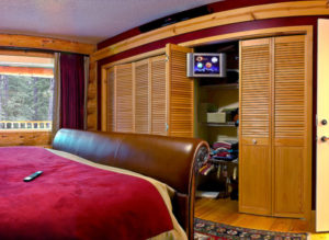Custom Home Solution with audio video and home automation bedroom with tv screen in closet.